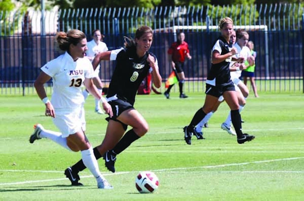Soccer ROUGH DAY: Senior midfielder Alexandra Elston looks for an open teammate with Central Florida senior Lauren Halbert in pursuit. The Knights topped the Sun Devils 5-0 Sunday afternoon. (Photo by Beth Easterbrook)