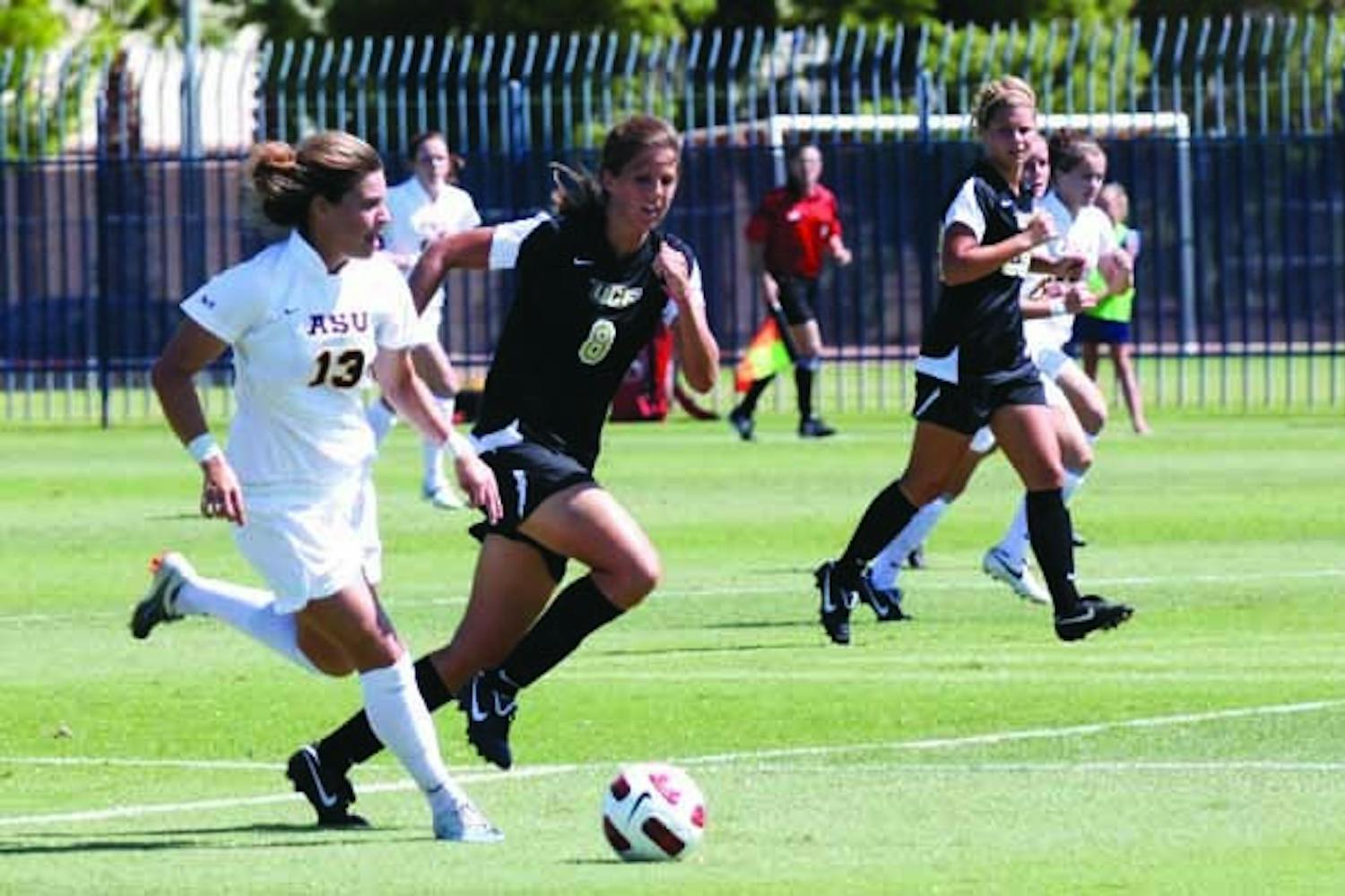 Soccer ROUGH DAY: Senior midfielder Alexandra Elston looks for an open teammate with Central Florida senior Lauren Halbert in pursuit. The Knights topped the Sun Devils 5-0 Sunday afternoon. (Photo by Beth Easterbrook)