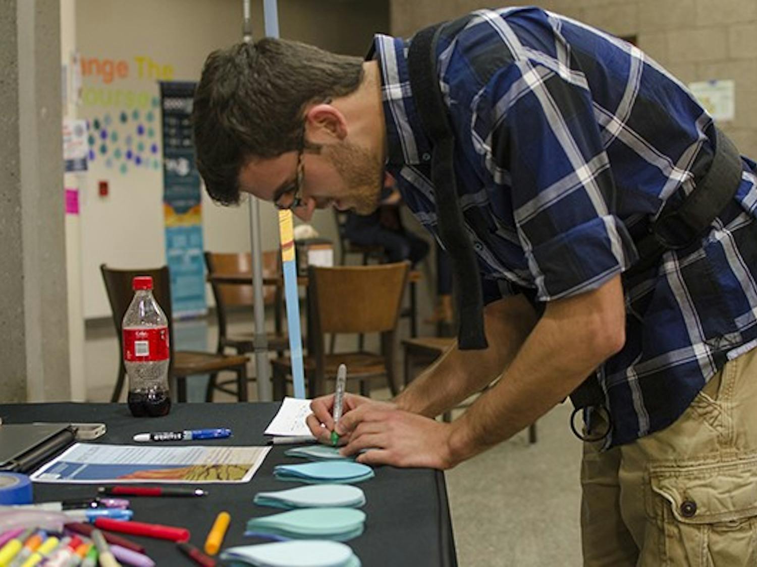 Wednesday, Nov. 12 - Nathan Francois (cq), a freshman studying biomedical engineering at Arizona State University, signs a pledge to conserve water as part of a larger campaign to restore 140 million gallons of water to the Colorado River. Photo by Ethan Fichtner.