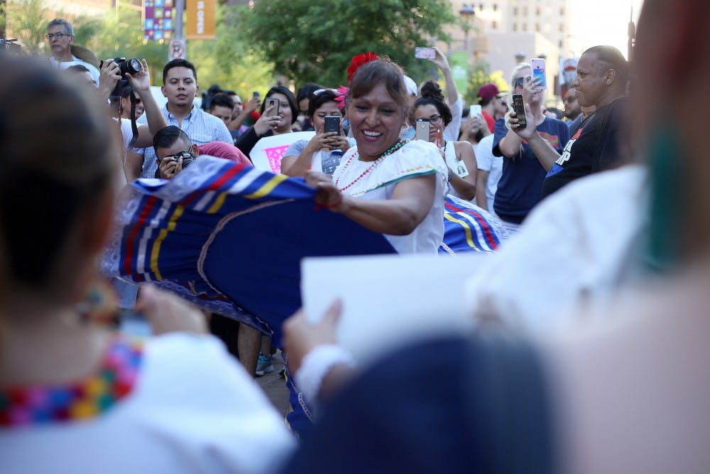 Maricruz Ramirez dances outside of the Trump rally in downtown Phoenix on Wednesday, Aug. 31, 2016. 
