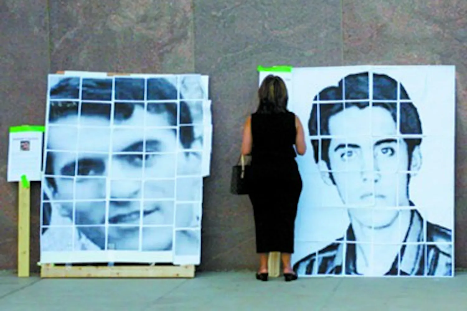 A woman stands before photos of two Iranian students on Saturday evening at the state Capitol. The students were imprisoned last year for protesting the 2009 presidential election. (Rheyanne Weaver)