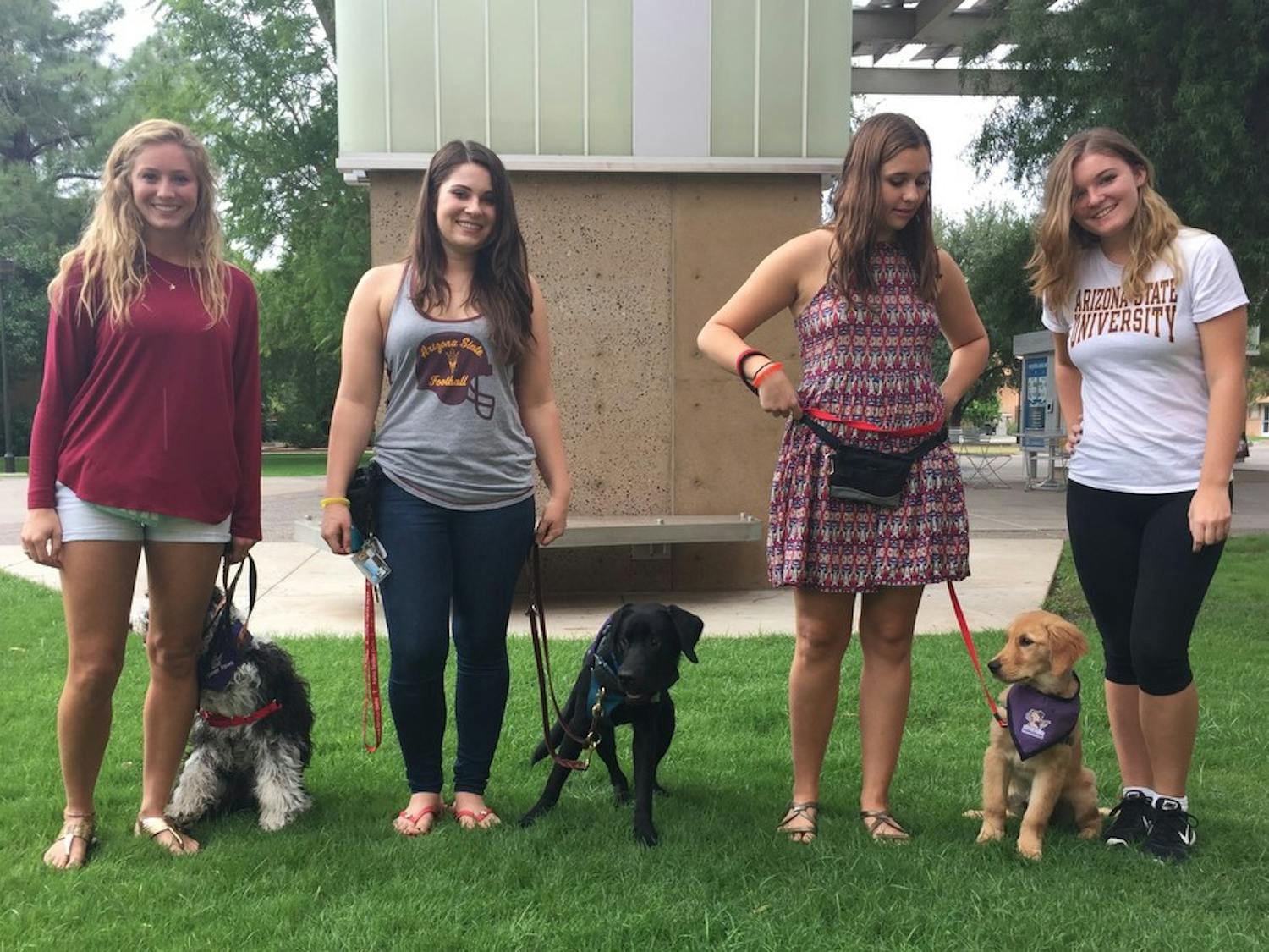Biology sophomore Sydney McClure, kinesiology junior Taylor Randle, chemical engineering junior Rhiannon Olshansky and psychology sophomore Samantha Rodrigues pose with their service dogs Castle, Kristoff and McKenzie at the Memorial Union in Tempe on Saturday, Oct. 17, 2015.