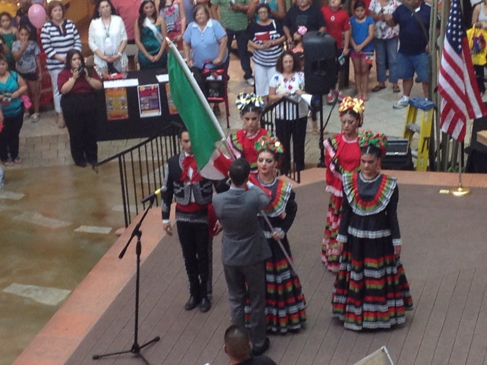 Colorguards dressed in traditional Mexican costumes give the Mexican flag to the consulate. Photo by Alec Damiano.