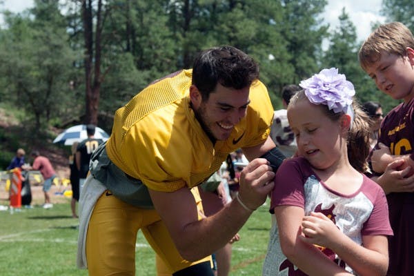 Then-redshirt junior quarterback Mike Bercovici signs a Sun Devil fan's shirt at Camp Tontozona on Aug. 16, 2014. (Photo by Mario Mendez)
