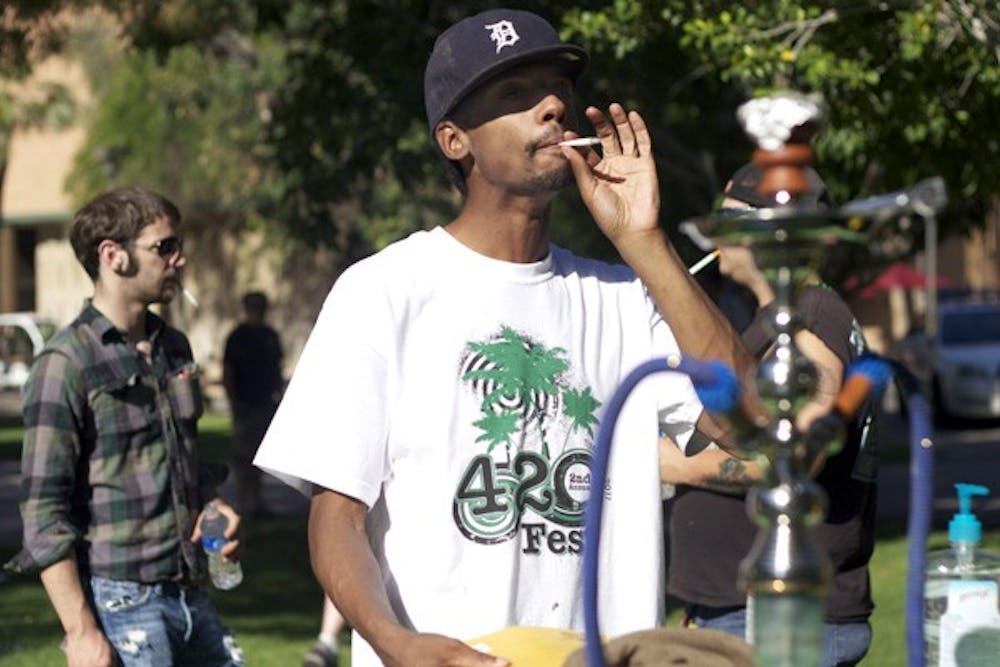 SMOKE OUT: Chris Armstrong, a 32-year-old Tempe resident, celebrates 4/20 at ASU by lighting up an herb-filled joint with his friends. The event was held Wednesday afternoon outside Discovery Hall on the ASU Tempe Campus. (Photo by Scott Stuk)