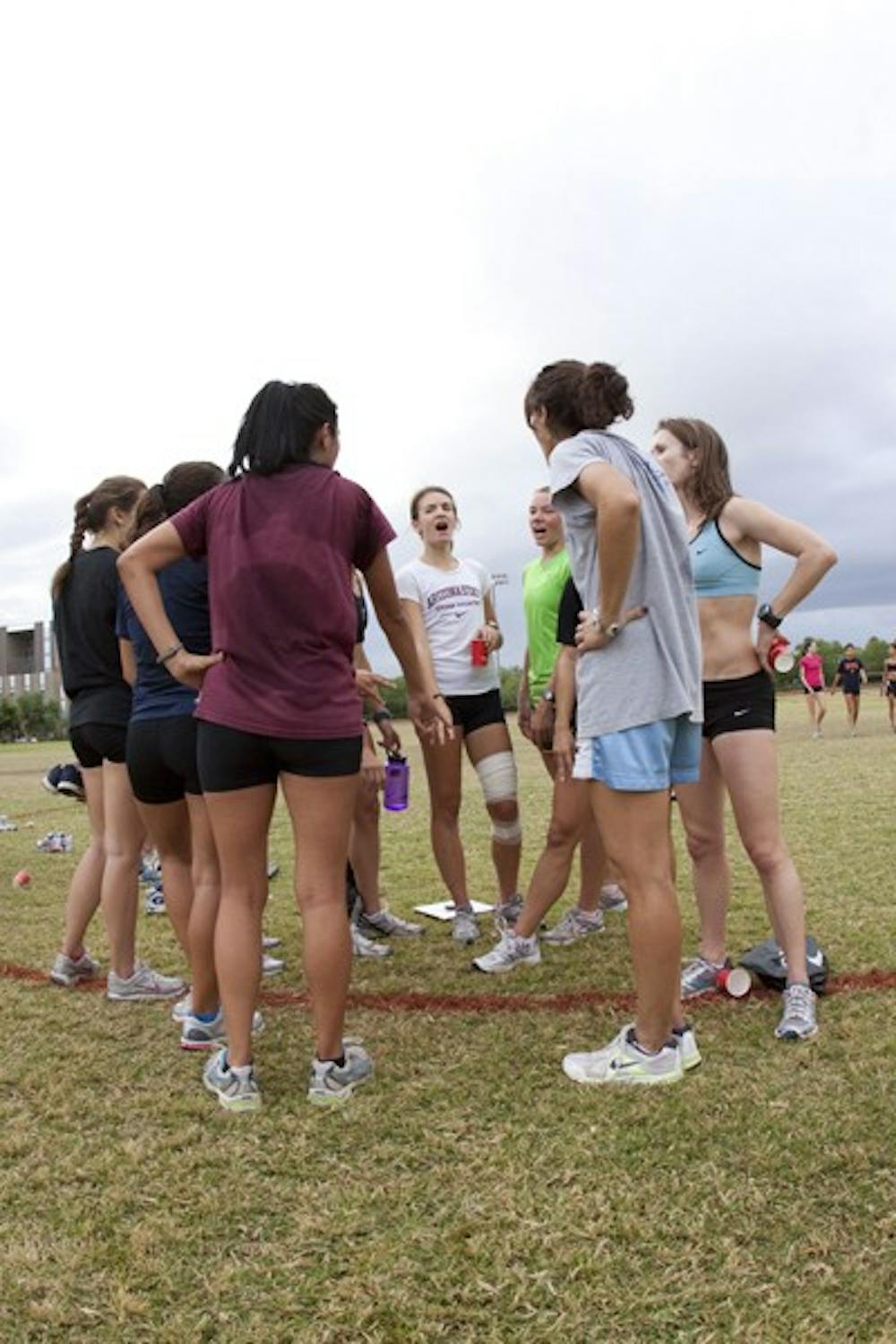 TEAM HUDDLE: The cross country women's team ends practice last season on a positive note with a team cheer. (Photo by Annie Wechter)