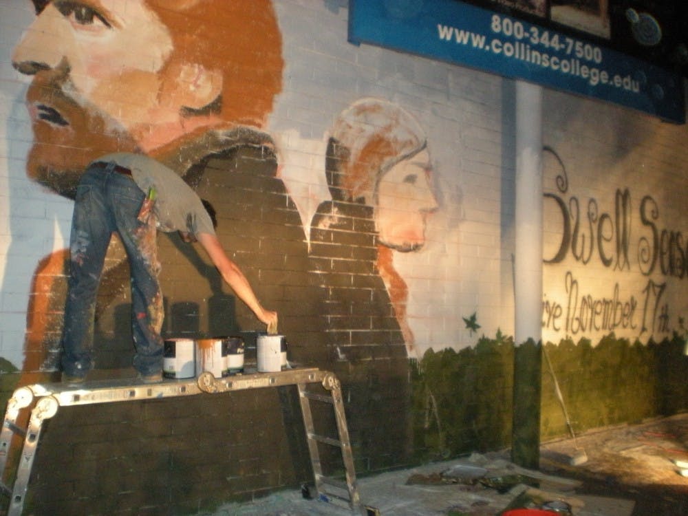 An artist paints a mural during First Friday. Photo by Chelsea Brown. 