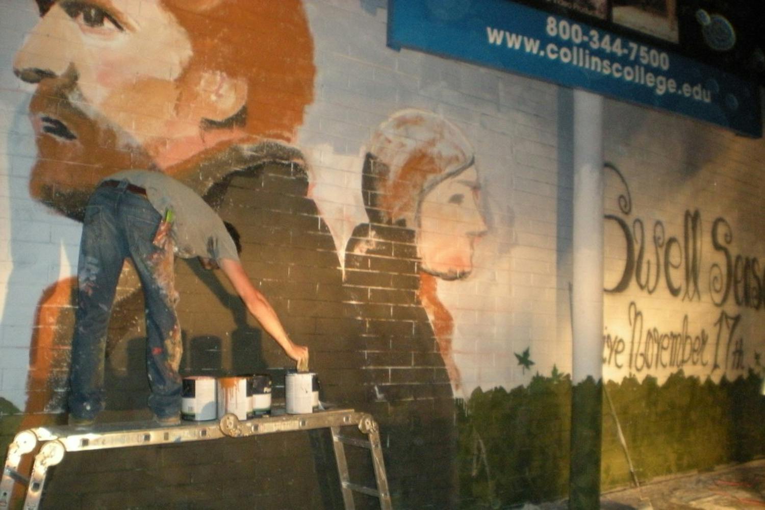 An artist paints a mural during First Friday. Photo by Chelsea Brown.