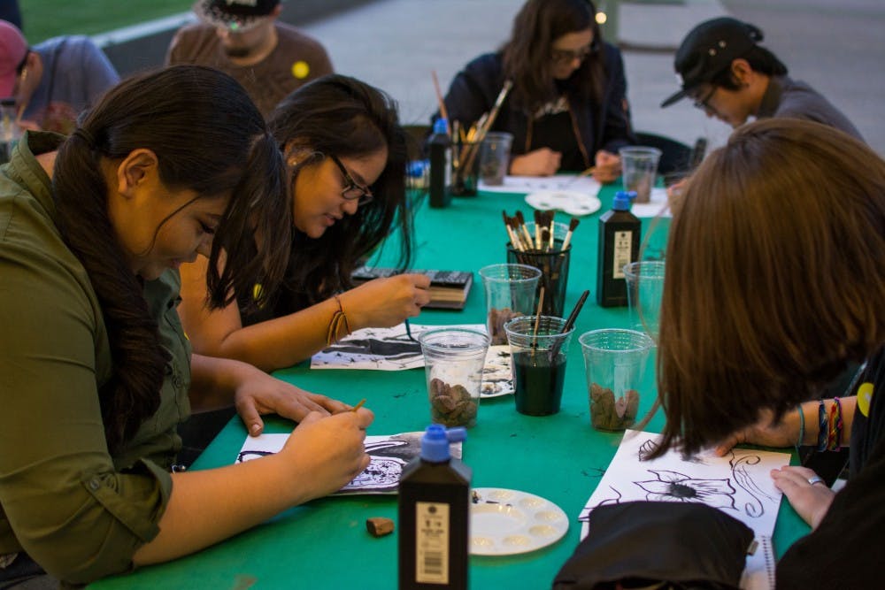 Students gather at an activity table outside the Phoenix Art Museum on Wednesday, March 29, 2017 and create art as part of the museums first-ever College Night. 