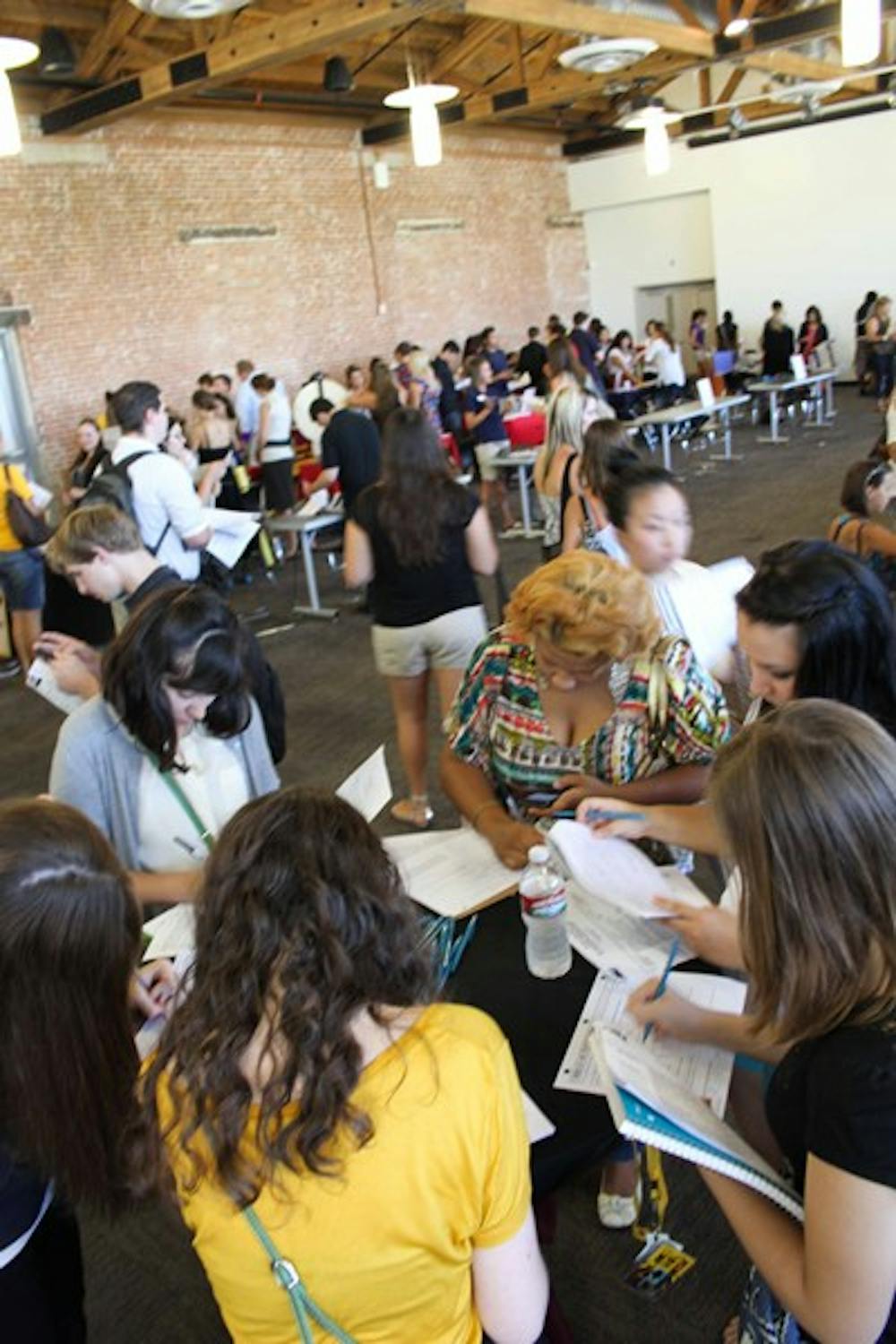JOB SEARCH: Students fill out applications at the job fair on the downtown campus Friday afternoon.  Each semester the job fair features booths from all different valley employers, from the Phoenix Zoo to 620 KTAR. (Photo by Lisa Bartoli)