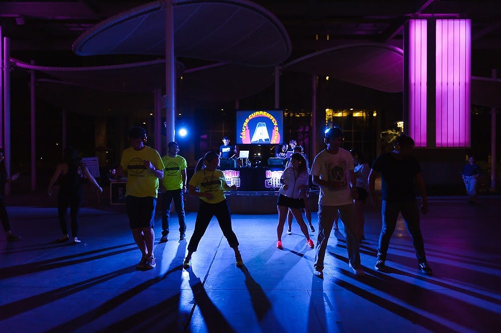 People dance at the Headphone Disco near the North Stage of the Memorial Union on Friday, March 27, 2015. (Ben Moffat/The State Press)