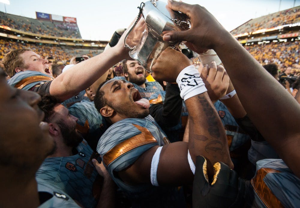 Redshirt freshman linebacker Ismael Murphy-Richardson celebrates with the Territorial Cup after defeating UA on Saturday, Nov. 21, 2015, at Sun Devil Stadium in Tempe.