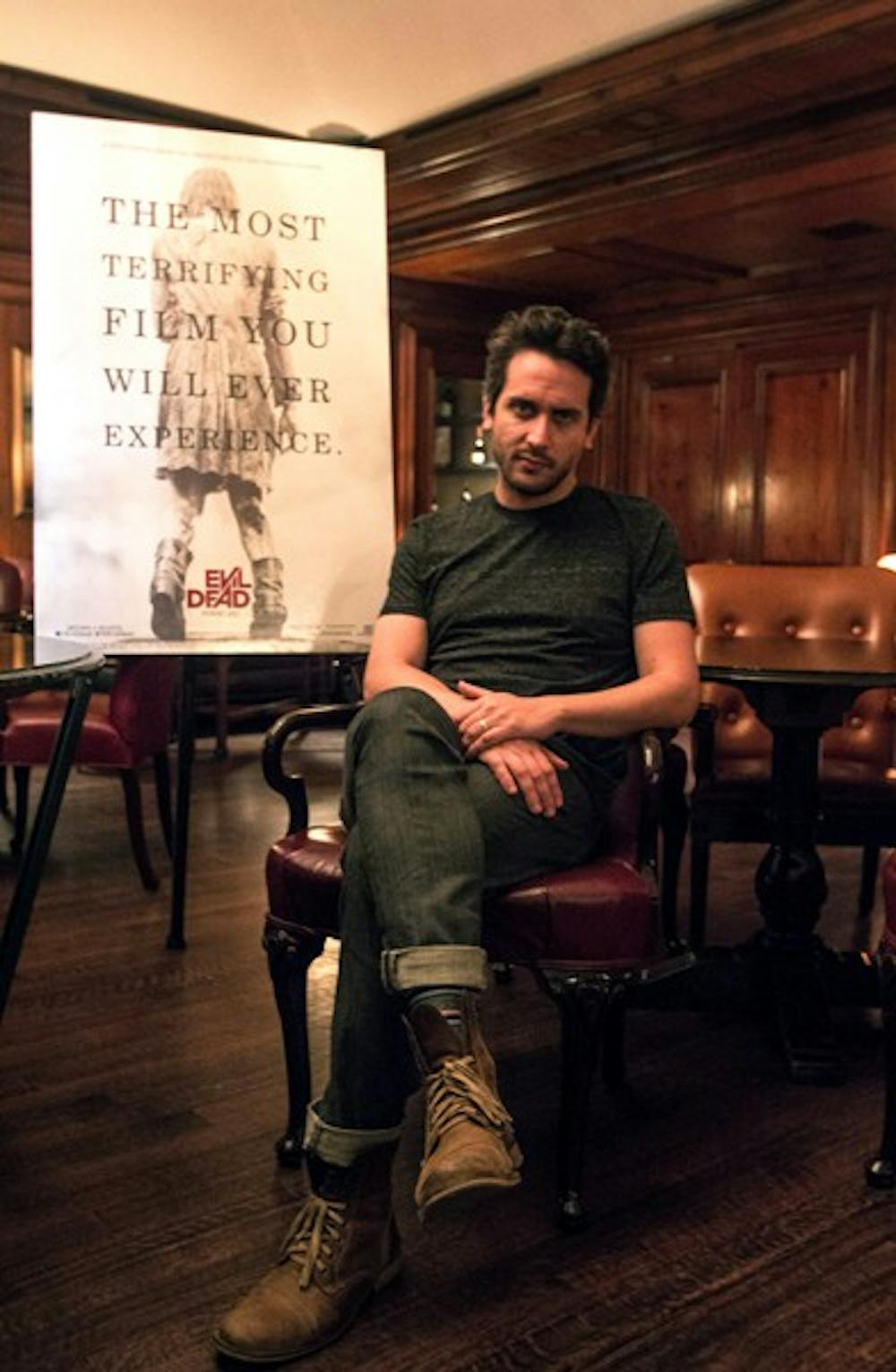 Fede Alvarez sits next to his Evil Dead poster at the Ritz Carlton in Phoenix. The movie is scheduled to come out in early April of this year. (Photo by Dominic Valente)
