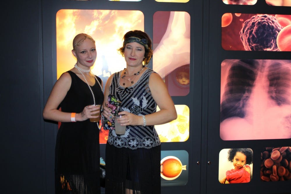 Rachel Sugihara, left, and Jenny Davie take part in Friday's 1920s-themed festivities at the Arizona Science Center.&nbsp;The monthly events are designed to engage local adults.