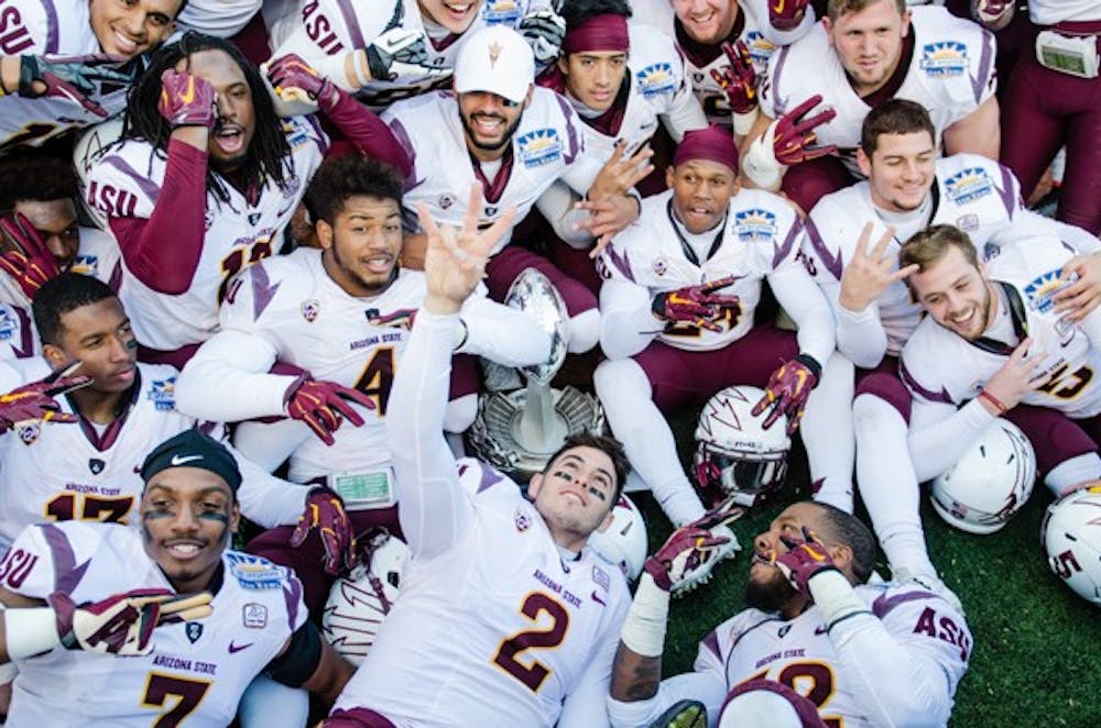 The ASU football team poses for photos with the Sun Bowl trophy, Saturday, Dec. 27, 2014 at Sun Bowl Stadium in El Paso. The Sun Devils defeated the Blue Devils 36-31. (Ben Moffat/The State Press)