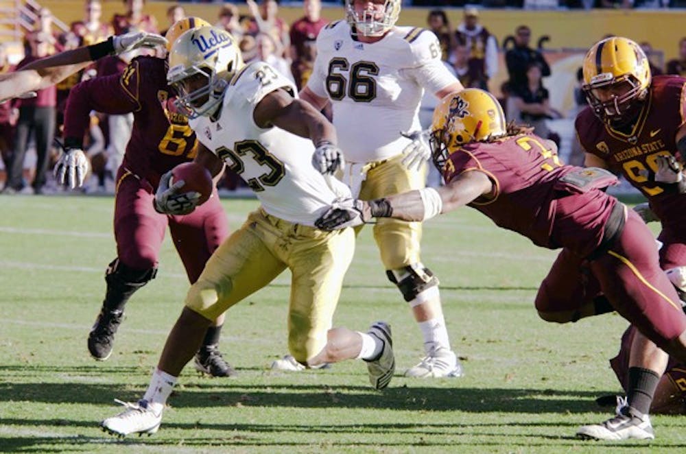 GREAT LENGTHS: Redshirt senior cornerback Omar Bolden reaches for a tackle against UCLA junior fullback Damien Thigpen in the Sun Devils’ meeting against the Bruins last November. Bolden’s return from an ACL tear remains uncertain despite speculation of a comeback that surfaced earlier this week. (Photo by Aaron Lavinsky)