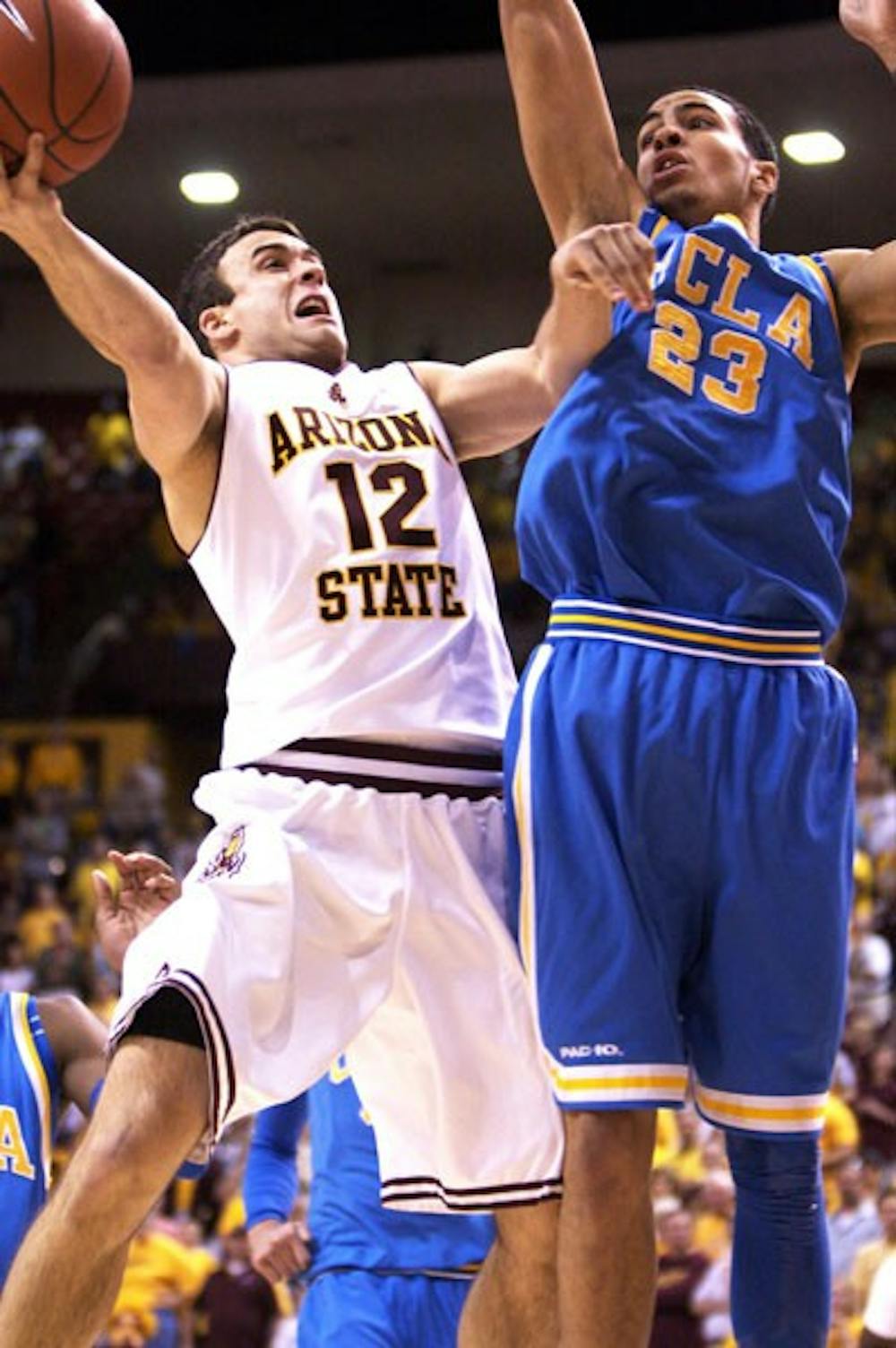 PUSH HIM BACK: Senior guard Derek Glasser attempts to lay the ball up over UCLA freshman Tyler Honeycutt last week. (Photo by Scott Stuk)