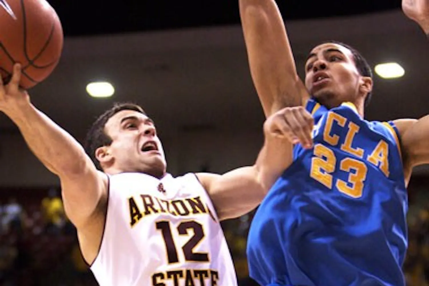 PUSH HIM BACK: Senior guard Derek Glasser attempts to lay the ball up over UCLA freshman Tyler Honeycutt last week. (Photo by Scott Stuk)