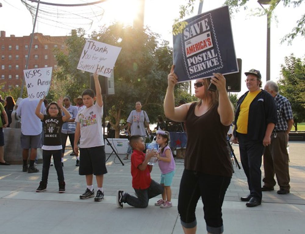 DOWNTOWN DEMONSTRATION: Lori Usky, a post office clerk from Tolleson, Ariz., stands with her family at a protest near the Downtown campus in support of HR 1351. (Photo by Tiana Chavez)