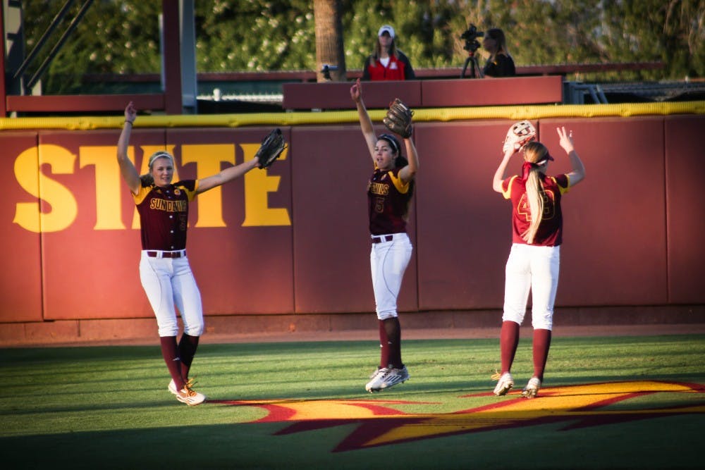Senior Abby Spiel (#3), Senior Jennifer Soria (#5), and Sophomore Nichole Chilson (#49) huddle together in the outfield and then explode out in team spirit at the ASU vs Arizona softball game on March 18, 2016.
