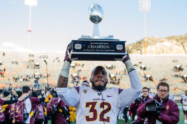 Redshirt junior linebacker Antonio Longing celebrates with the Sun Bowl trophy, Saturday, Dec. 27, 2014 at Sun Bowl Stadium in El Paso. The Sun Devils defeated the Blue Devils 36-31. (Ben Moffat/The State Press)