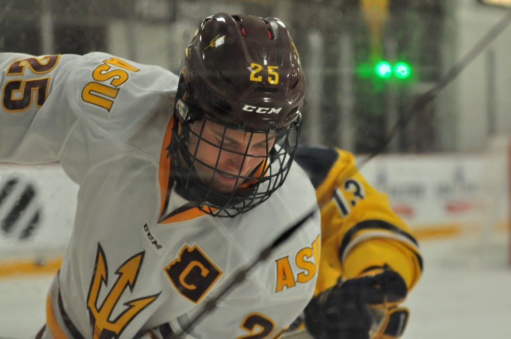 Senior defenseman Liam Norris battles for the puck along the boards at Oceanside Ice Arena in Tempe in&nbsp;ASU hockey's 7-1 win over Southern New Hampshire on Oct. 24, 2015.
