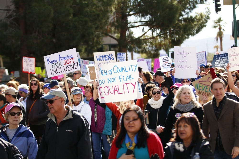 Protesters hold up signs at the Women’s March in downtown Phoenix on Saturday Jan. 21, 2017.