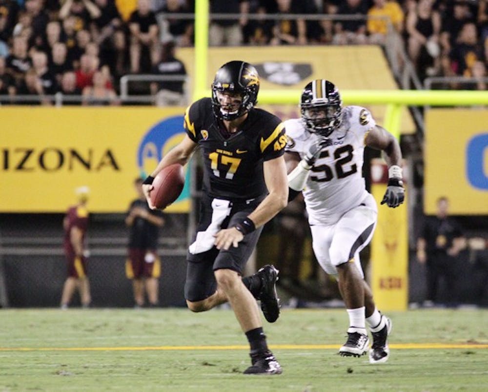 UNDER PRESSURE: Junior quarterback Brock Osweiler attempts to escape from Missouri redshirt sophomore defensive lineman Michael Sam in the Sun Devils’ 37-30 overtime win over the Tigers. Coach Dennis Erickson said that Osweiler has improved noticeably in the pocket over the season. (Photo by Beth Easterbrook)