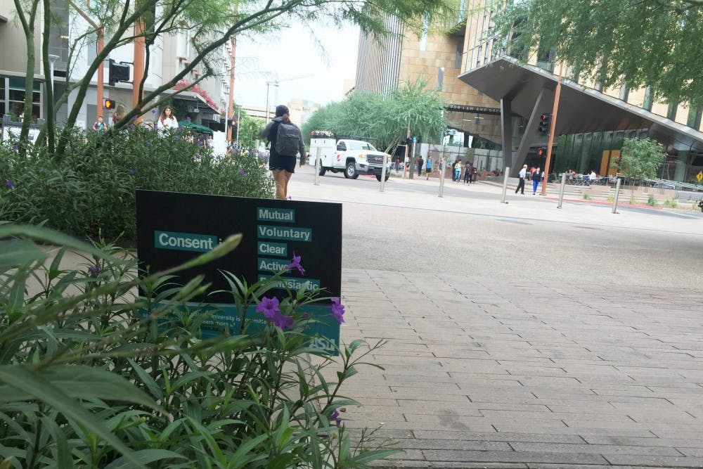 An educational sign on consent slightly obscured by bushes on the Downtown campus on September 27, 2016.