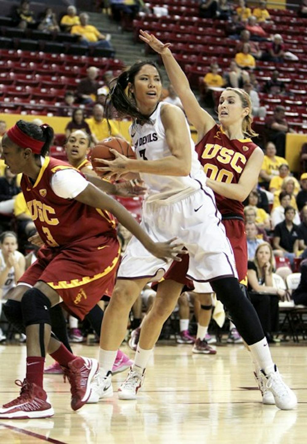 Redshirt junior center Joy Burke shifts the ball away from the reach of a USC defender on March 3. Burke is one of the many young players with experience that will return for the Sun Devils next season. (Photo by Sam Rosenbaum)