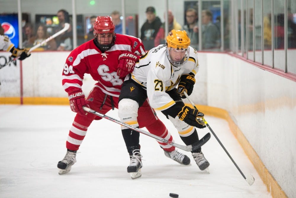 ASU forward Michael Cummings battles for the puck with Stony Brook's Joseph Bochichio behind the net on Jan. 22, 2015, at Oceanside Arena in Tempe.&nbsp;