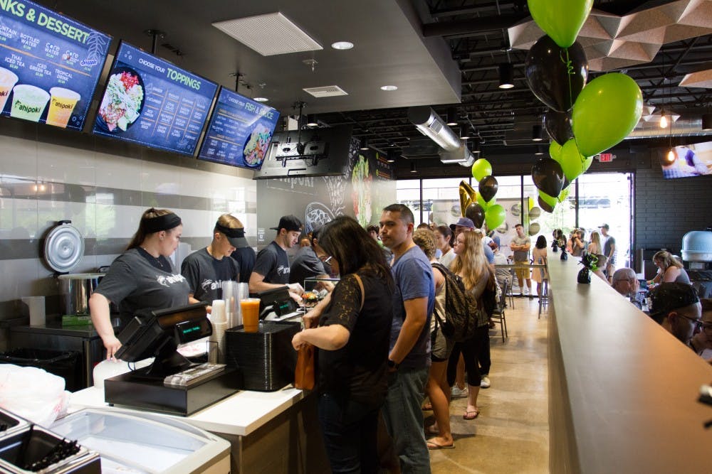 The line of customers flows out onto the sidewalk during the grand opening of Ahipoki Bowl on Saturday, March 25, 2017 in Tempe, Arizona.