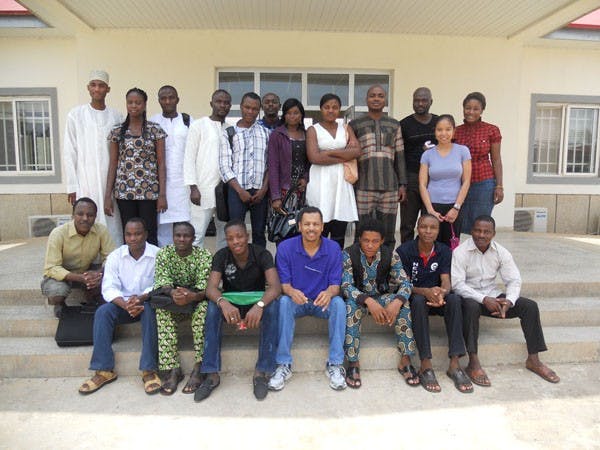Engineering professor Terry Alford sits with a group of students he met on one of his trips to Africa.  Alford and colleagues at the university use computers to help students in South Africa receive better educations, especially in science. (Photo courtesy of Terry Alford) 