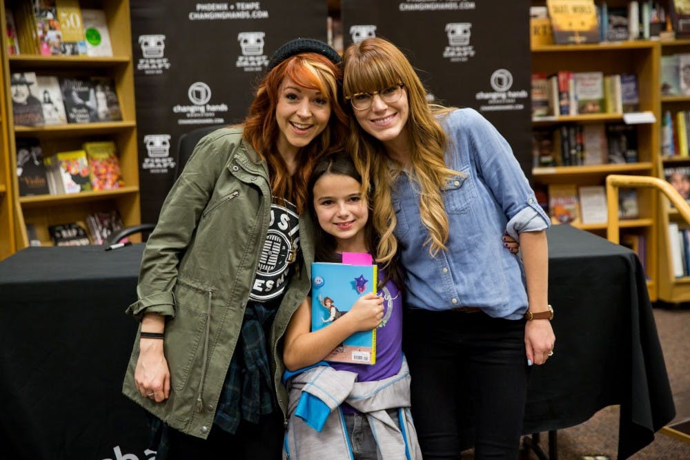 ASU alumna&nbsp;Brooke Passey and Lindsey Stirling pose for a photo&nbsp;with a young fan of "The Only Pirate at the Party" at a book signing event.