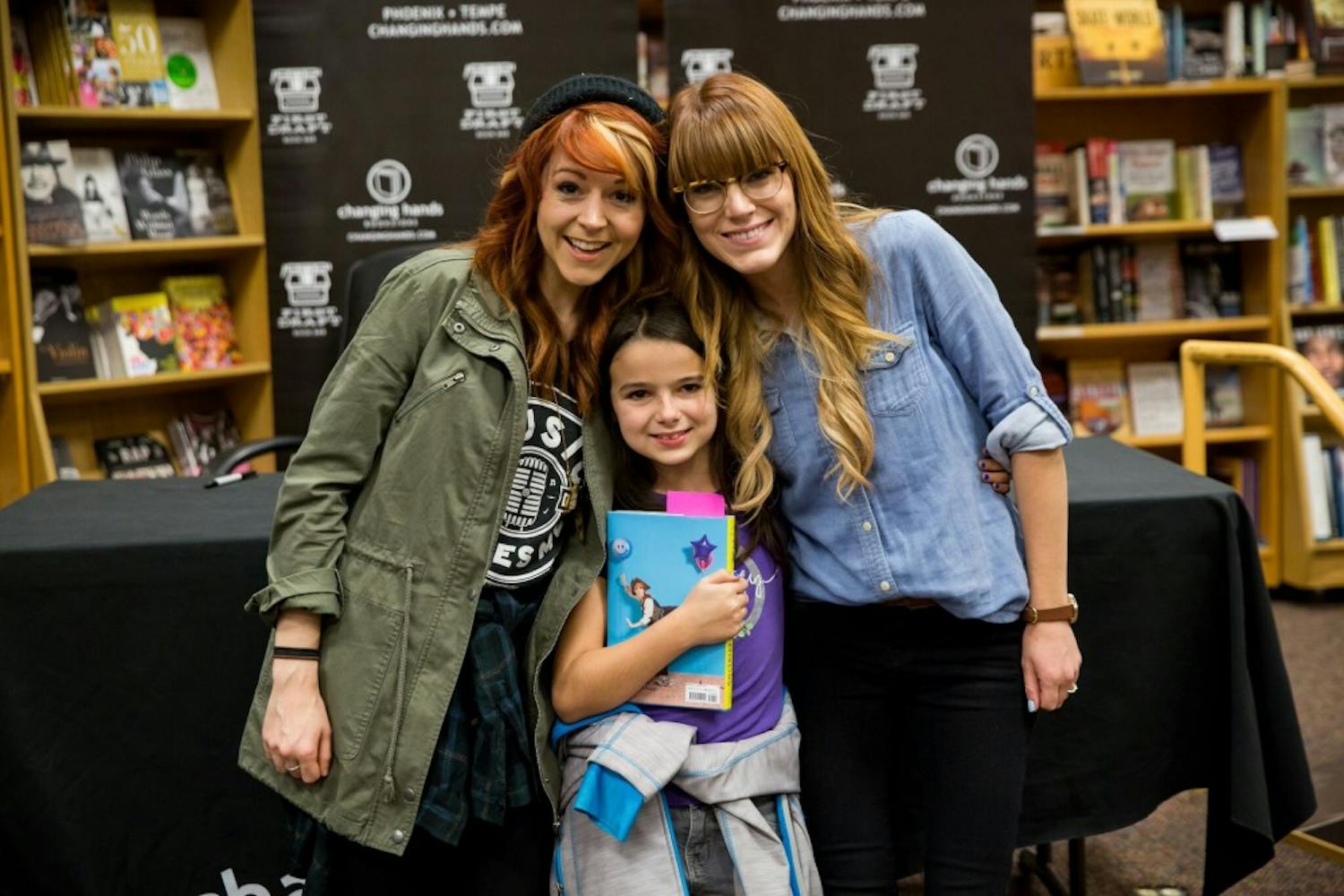 ASU alumna Brooke Passey and Lindsey Stirling pose for a photo with a young fan of "The Only Pirate at the Party" at a book signing event.