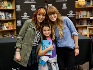 ASU alumna&nbsp;Brooke Passey and Lindsey Stirling pose for a photo&nbsp;with a young fan of "The Only Pirate at the Party" at a book signing event.