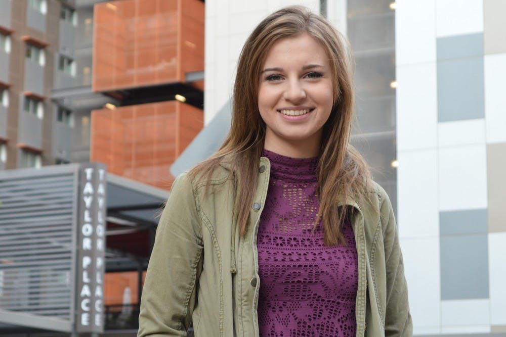 Journalism sophomore Katie Malles poses for a portrait in front of Taylor Place on the Downtown campus on Monday, Nov. 16, 2015. Taylor Place is home to many of the subjects featured in her portrait project 'Students of Downtown.'