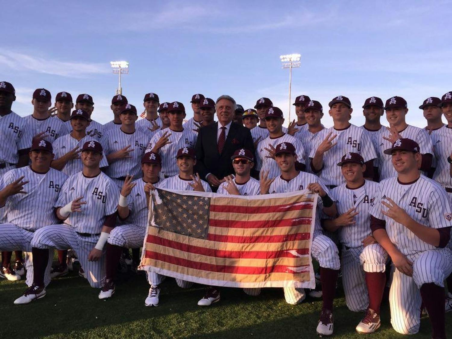Rick Monday, middle, poses with the ASU baseball team before a game against Arizona on Tuesday, April 26, 2016 at Phoenix Municipal Stadium in Tempe, Arizona. The team was honoring&nbsp;Monday, an ASU alumnus, for the 40-year anniversary of him&nbsp;saving a flag that was being burnt in protest at Dodger Stadium.