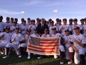 Rick Monday, middle, poses with the ASU baseball team before a game against Arizona on Tuesday, April 26, 2016 at Phoenix Municipal Stadium in Tempe, Arizona. The team was honoring&nbsp;Monday, an ASU alumnus, for the 40-year anniversary of him&nbsp;saving a flag that was being burnt in protest at Dodger Stadium.