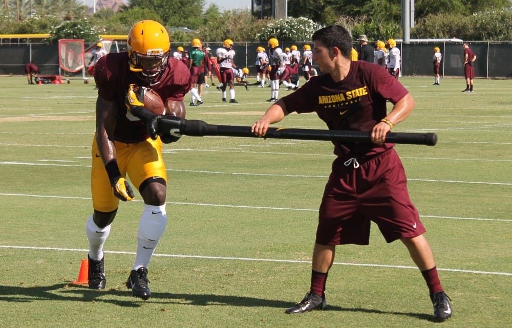 ASU running backs work to hold onto the football during a drill at practice. (Photo: Justin Janssen)