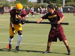 ASU running backs work to hold onto the football during a drill at practice. (Photo: Justin Janssen)