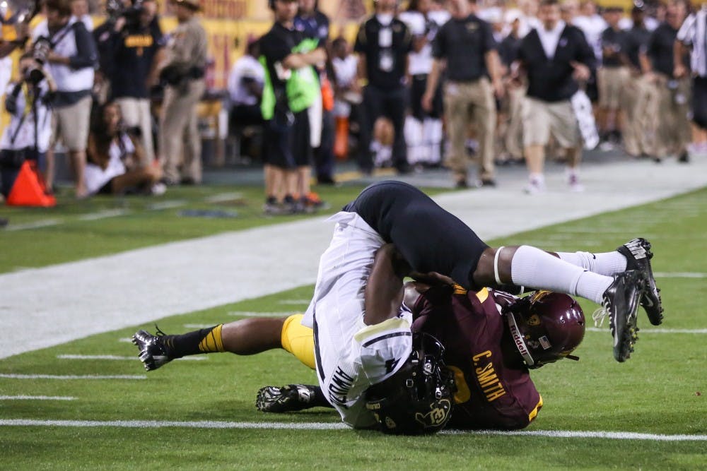 Sophomore receiver Cameron Smith is tackled by Chidobe Awuzie of Colorado during the 2013 season. ASU won the game 54-13. (Photo by Arianna Grainey)