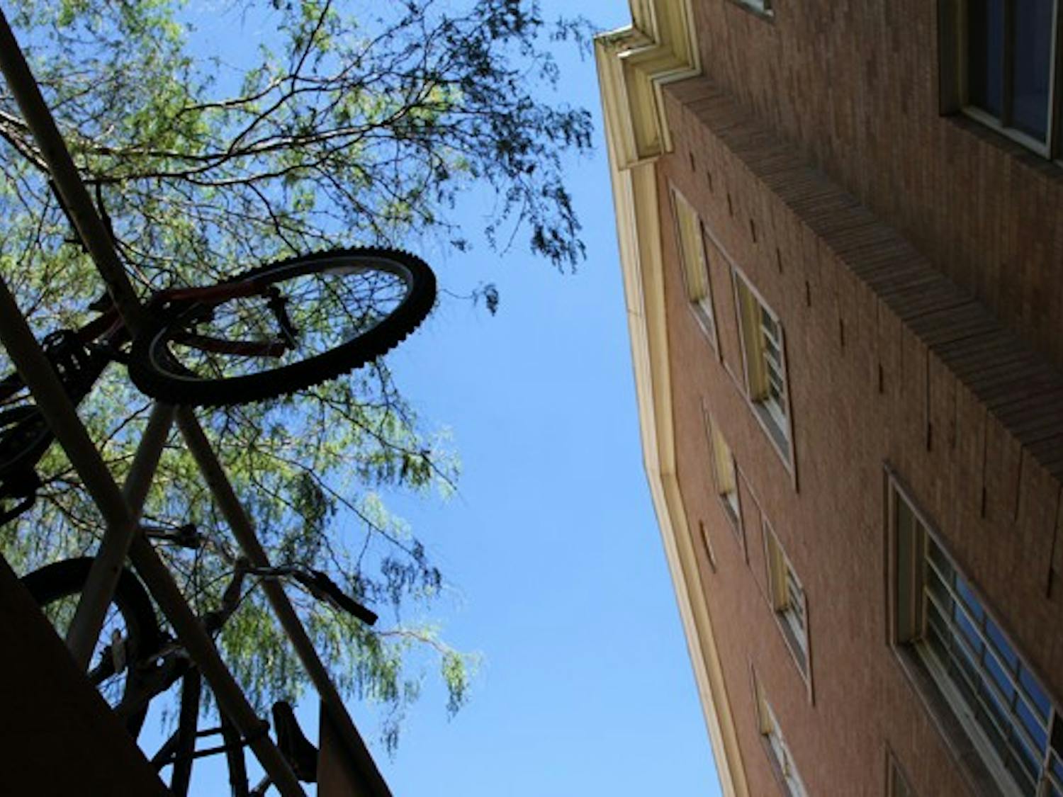 SUSPENDING BIKES: Bikes hang over the rails outside of Matthews Hall in Tempe last Wednesday afternoon. (Photo by Rosie Gochnour)