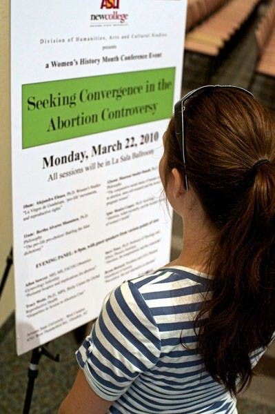 THE HOT TOPIC: A student on the West campus previews the day's schedule for the daylong abortion-themed conference. "Seeking Coverage in the Abortion Controversy" features various ASU professors who speak on topics ranging from stem cell research to infant mortality. (Photo by Michael Arellano)