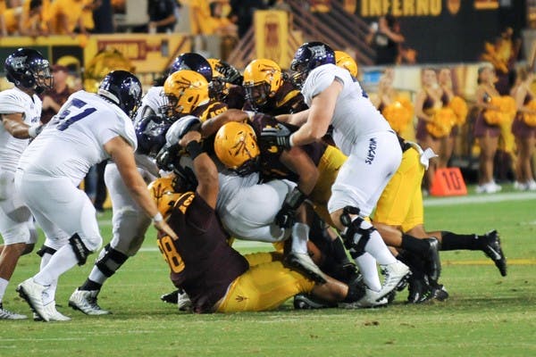 Wildcat sophomore running back Zach Smith gets taken down by the ASU defense. (Photo by Andrew Ybanez)