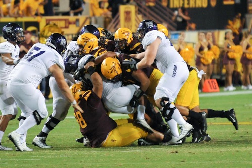 Wildcat sophomore running back Zach Smith gets taken down by the ASU defense. (Photo by Andrew Ybanez)
