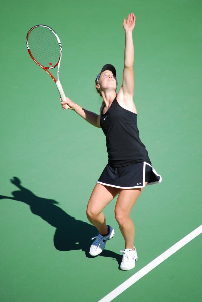 Senior Hannah James gently tosses the ball up in the air before smacking it down on a serve against Pepperdine on Feb. 23. The ASU tennis team will host three matches and will not compete in Tempe until April. (Photo by Murphy Bannerman)
