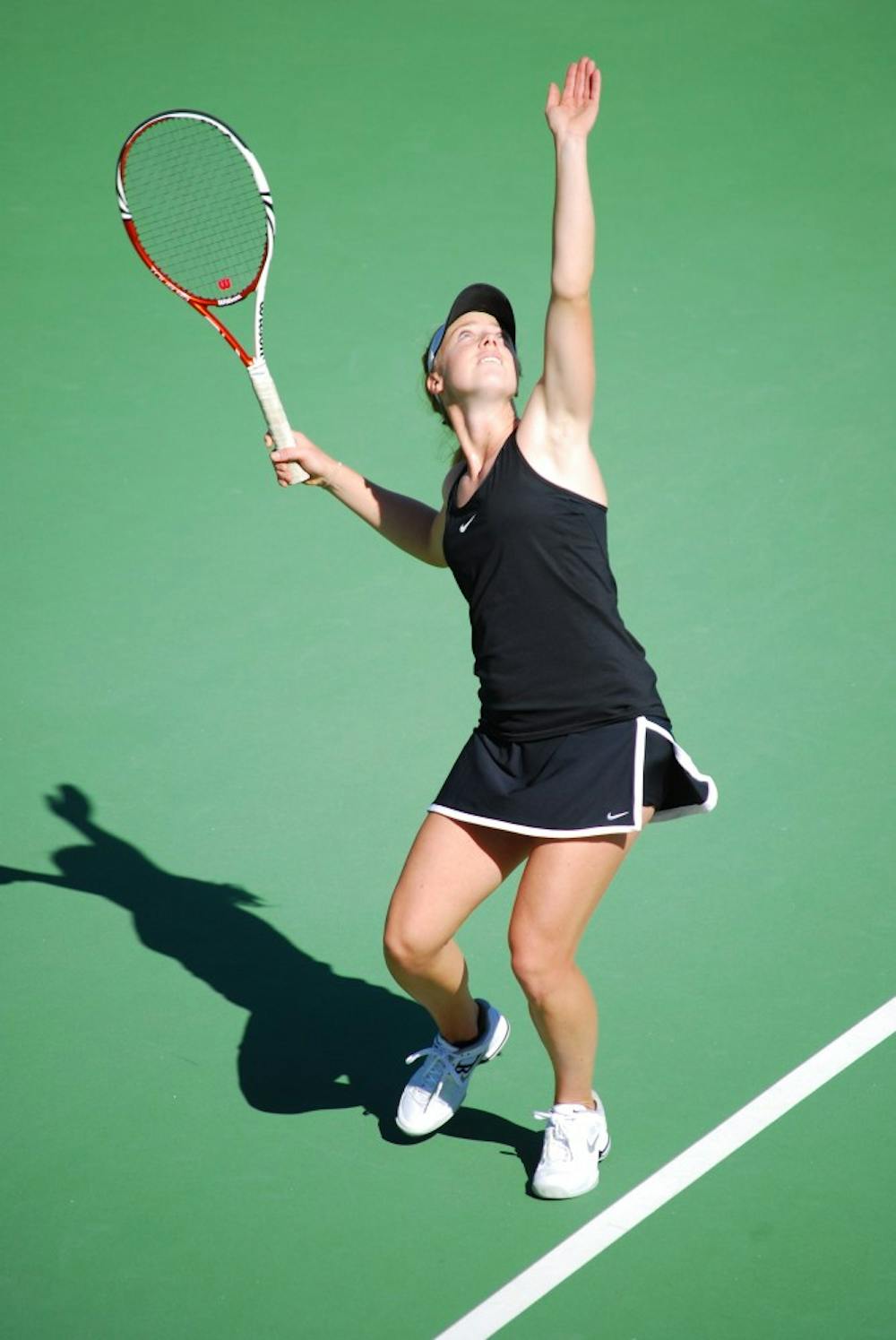 Senior Hannah James gently tosses the ball up in the air before smacking it down on a serve against Pepperdine on Feb. 23. The ASU tennis team will host three matches and will not compete in Tempe until April. (Photo by Murphy Bannerman)
