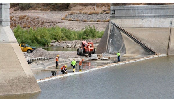 HARD WORK: Construction workers attend to the Western embankment of Tempe Town Lake on Friday morning. Restoration of the lake is set to be finished in November. (Photo by Serwaa Adu-Tutu)