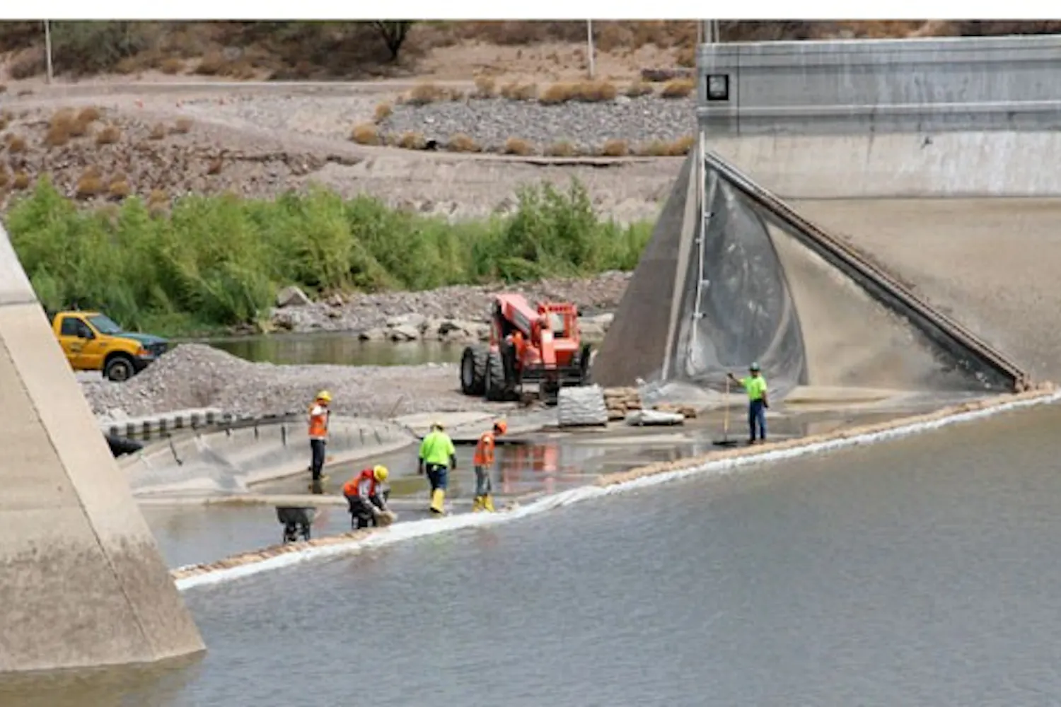 HARD WORK: Construction workers attend to the Western embankment of Tempe Town Lake on Friday morning. Restoration of the lake is set to be finished in November. (Photo by Serwaa Adu-Tutu)